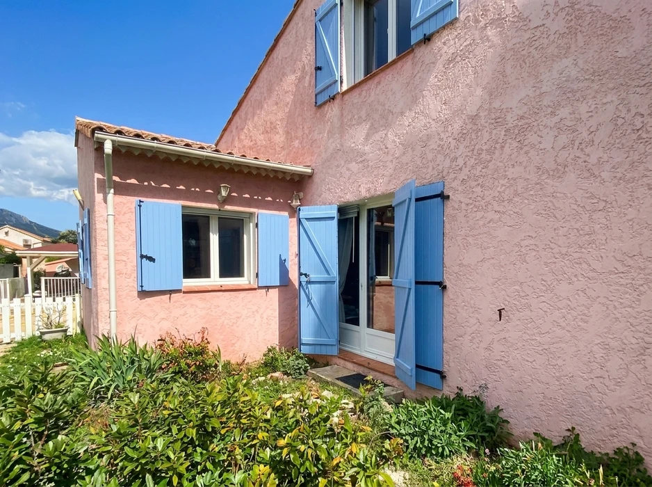 Maison provençale à enduit rose texturé, volets bois peints en bleu lavande, fenêtres PVC blanc à double vitrage, porte-fenêtre deux vantaux