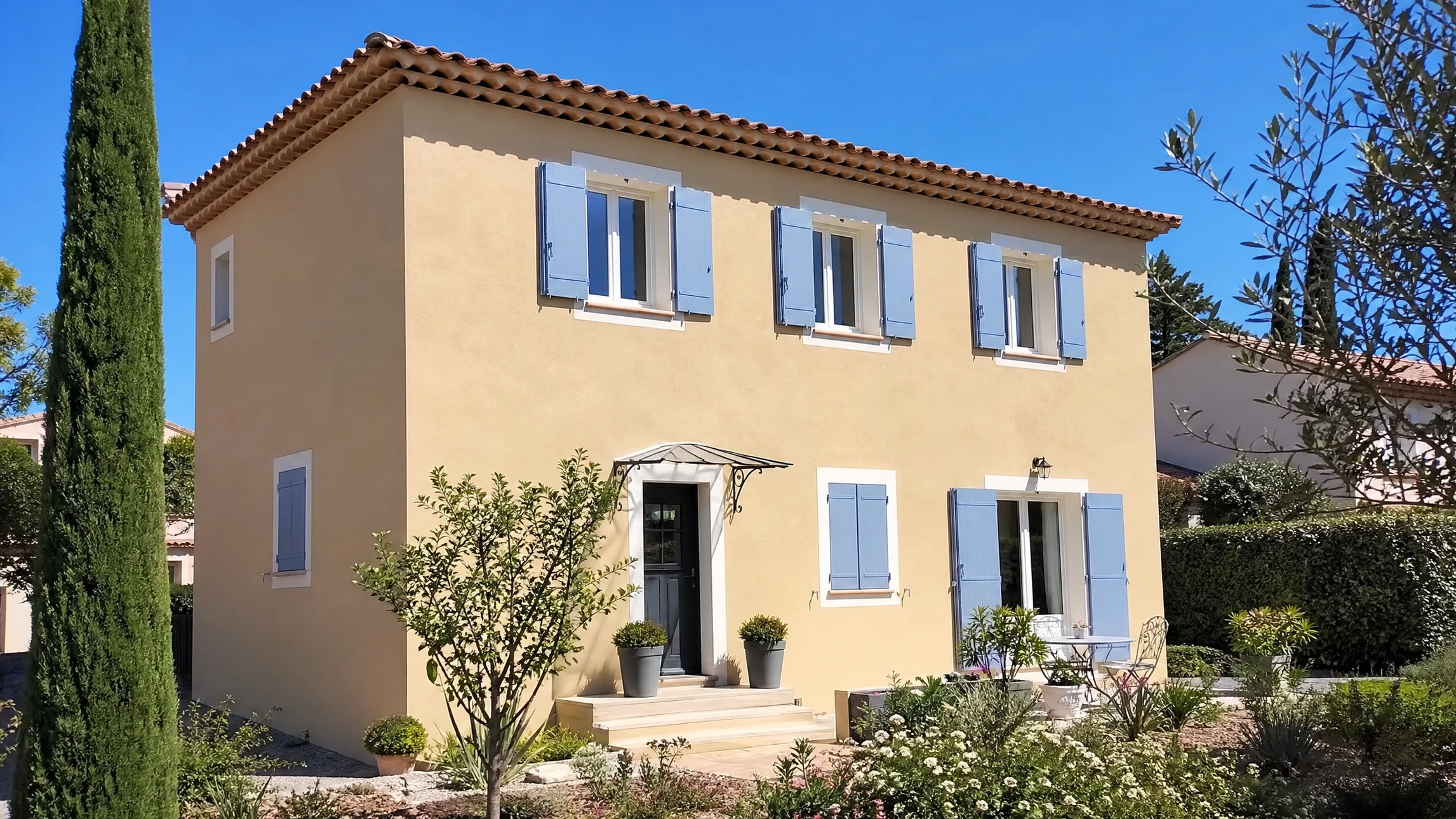 Ouvrier en bâtiment appliquant un enduit sur façade extérieure, portant casque de sécurité jaune et vêtements de travail