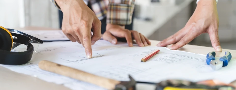 jeune homme d'affaires ingénieur professionnel sur le chantier de construction de l'immeuble à la maison avec un plan
